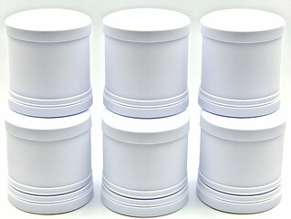 Obraz premium Six White Cylindrical Containers with Lids Stand on a White Surface, Ready for Use.