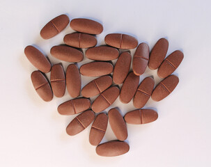 Group of brown vitamin pills medicine on a white background