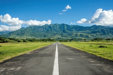 Naklejka premium Scenic View of a Clear Airstrip with Majestic Mountains and Lush Greenery Under a Bright Blue Sky and Fluffy White Clouds in a Serene Landscape