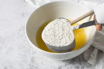 overhead view of All purpose flour in a measuring cup, baking flour in a steel measuring cup