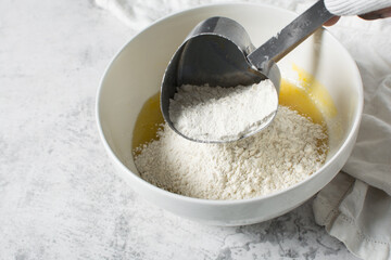 overhead view of All purpose flour in a measuring cup, baking flour in a steel measuring cup