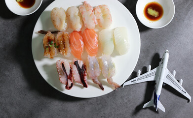 Various sushi on a white plate. Various sushi on white plates with a miniature airplane.
