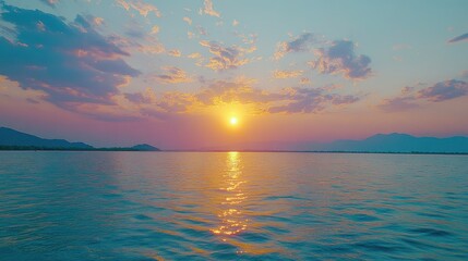 Obraz premium Sunset over calm lake, mountains backdrop