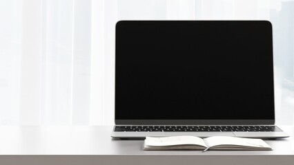 Desktop of modern gray stand up desk with computer laptop, notebook in sunlight from window for home office working, technology, lifestyle product background 3D