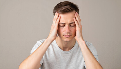 Stressed young man holding head in frustration, college admissions