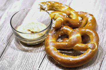 Two pretzels being eaten with mustard