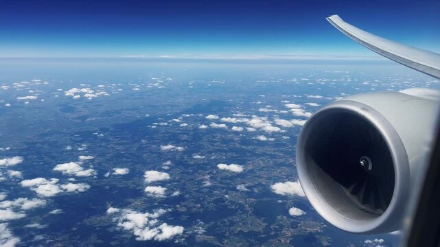 Turbine jet engine on an airliner flying on sunny day, pov from the passenger window