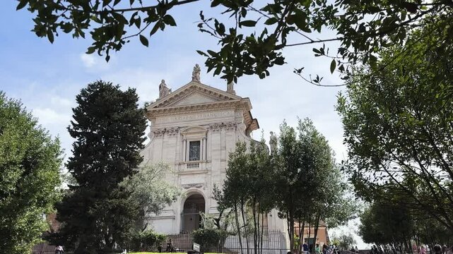 Cinematic view of Basilica Di Santa Francesca Romana in Roman Forum in Rome, Italy on spring sunny day surrounded by park trees with peaceful, serene atmosphere