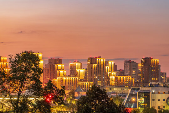Multi-storey buildings at night with illumination. Night colorful windows lights of the high-rise residential building in city sleeping area