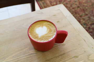 A cup of hot latte coffee on the table for breakfast
