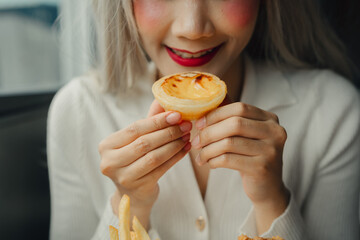 Delicious dessert with woman holding custard tart, smiling happily