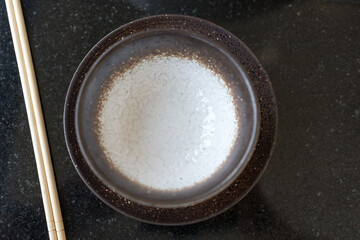 Empty ceramic bowl and wooden chopsticks for hot pot. Top view