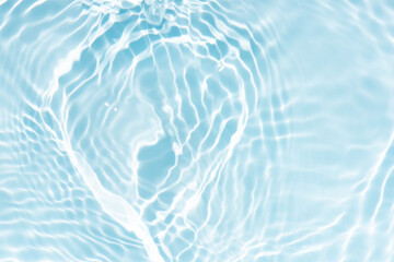 Blue water with ripples on the surface. Defocus blurred transparent blue colored clear calm water surface texture with splashes and bubbles. Water waves with shining pattern texture background.
