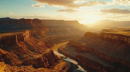 Sunset over a vast canyon with a river winding through it.