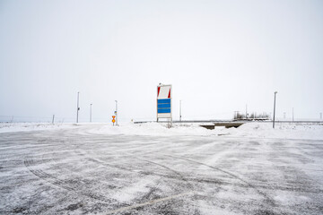 Empty road sign on Iceland road with snow capped field view in the winter. Mockup or Copy space. Nature, travel, winter background, or wallpaper