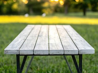 Naklejka premium White picnic table standing in a grassy field at sunset, creating a calm and natural ambiance