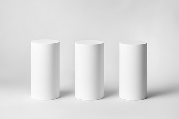 Three white cylindrical pedestals on a white background.