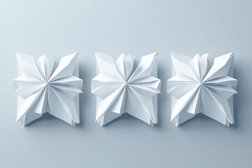 Three abstract white paper sculptures arranged in a row on a light gray background.