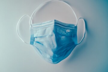 Single light blue disposable face mask on white background. (2)