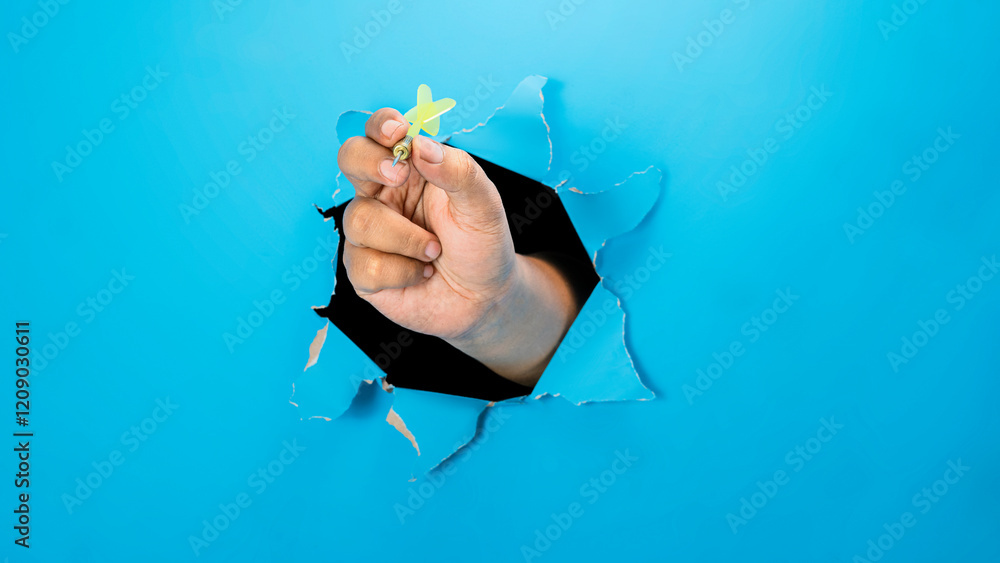 Poster a human hand holding a dart arrow through ripped paper. mockup or copy space. concept of target and 