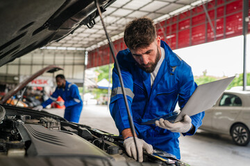 Male Auto mechanic are checking auto engine is problems at car repair shop.