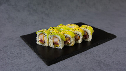 A delicious sushi roll filled with fresh avocado, crisp cucumber, and tender seafood, wrapped in a sheet of nori and sushi rice. 
