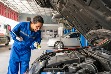 Female Auto mechanic are checking and repair maintenance auto engine is problems at car repair shop.