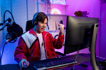 Asian young esport male gamer playing online video game on computer. 