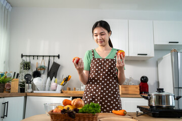 Asian young woman cooking healthy foods in kitchen in morning at home. 