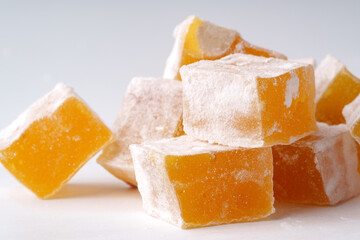 Delightful yellow Turkish delight cubes stacked artfully on a white surface showcasing their sugary coating and vibrant color