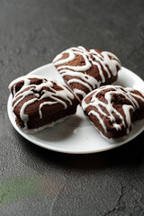 Delicious chocolate cookies with white icing on a plate, ready to be enjoyed in a cozy setting
