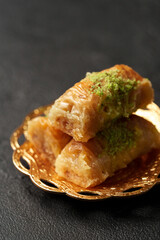 Delicious baklava dessert with pistachio topping served on a decorative plate