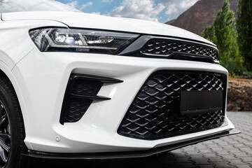 A white car with black grille and black bumper