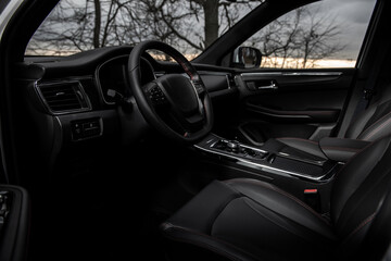 A black car with a steering wheel and a black leather seat