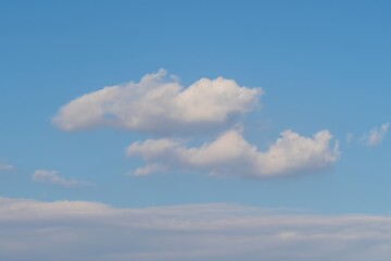 Clouds drift peacefully across a clear blue sky during a calm afternoon in early spring