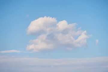 Soft white clouds drifting in a bright blue sky during a serene afternoon