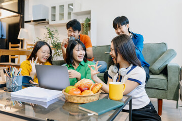 Learning online working concept. Asian college student working on tablet and laptop computer, searching knowledge in home.