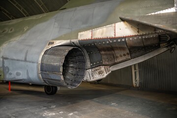 Detailed view of aircraft engine showing turbine and duct in aviation storage hangar during daylight hours