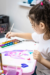  child painting a picture with school supplies, preschool child painting, child drawing a rainbow, child doing homework.