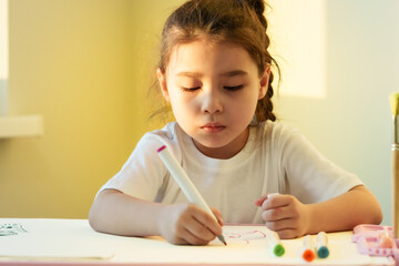 Creative child drawing at the desk at home or school class room