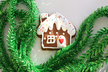 Gingerbread and green Christmas tree tinsel. Gingerbread house. Selective focus.