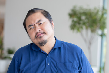 Angry Asian middle aged man with irritating expression, upset unhappy middle-age old real man staring at you with frustrated mood, upset and questioning emotion