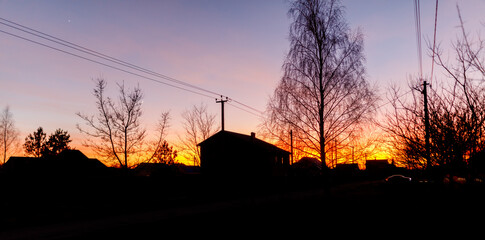 A beautiful sunset over a small town with a house in the foreground