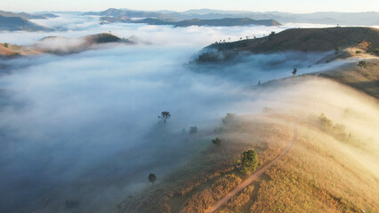 Landscape view of the sea of fog flowing on hills at dawn by drone
