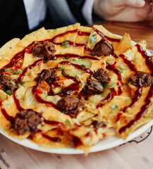Nachos with meat and cheese on the table in a restaurant