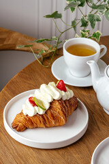 croissant with whipped cream and strawberries