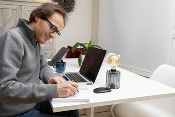 an entrepreneur is writing in his book and planning his day