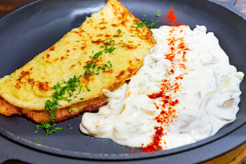 Delicious savory omelette served with creamy yogurt and spices Savory vegetable pie served with fresh garnishes on a white plate