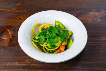 Fresh vegetable salad with herbs on rustic wooden table Savory vegetable pie served with fresh...