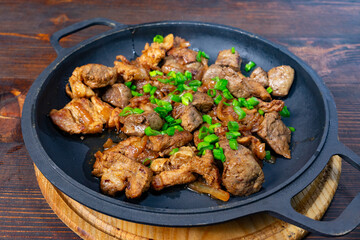 Beef and chicken sizzling on a skillet with fresh green onions Savory vegetable pie served with fresh garnishes on a white plate